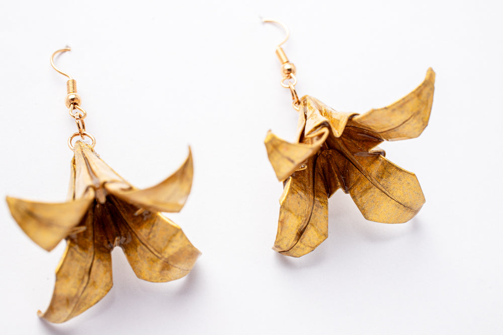 Aretes flor de borrachero en origami dorado | Joyería artesanal única