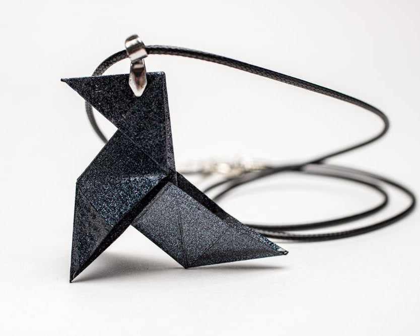 Colgante origami artesanal en papel cobre inspirado en La Casa de Papel sobre fondo blanco