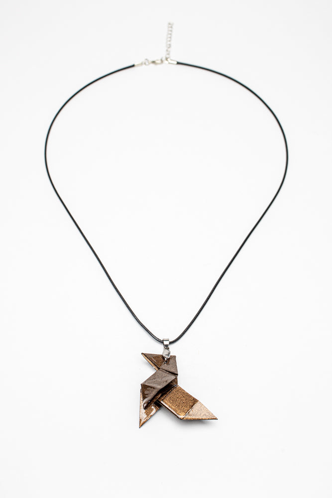 Colgante origami artesanal en papel bronce 2 inspirado en La Casa de Papel sobre fondo blanco