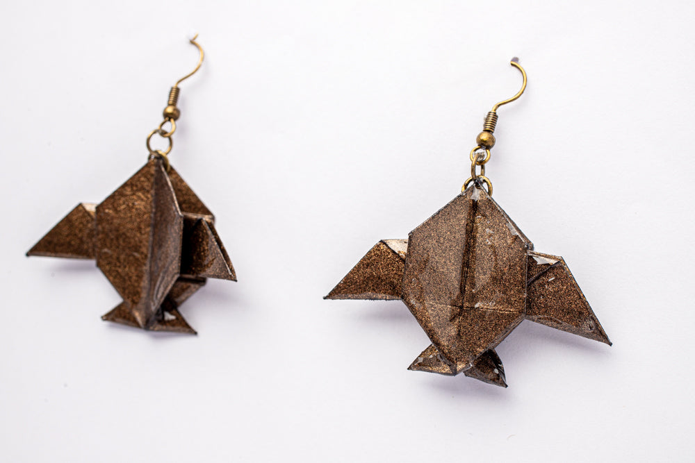Aretes origami en forma de peces Luna Bronce con acabado tornasolado sobre fondo blanco