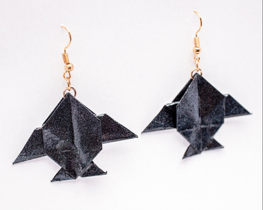 Aretes origami en forma de peces Luna Azul con acabado tornasolado sobre fondo blanco