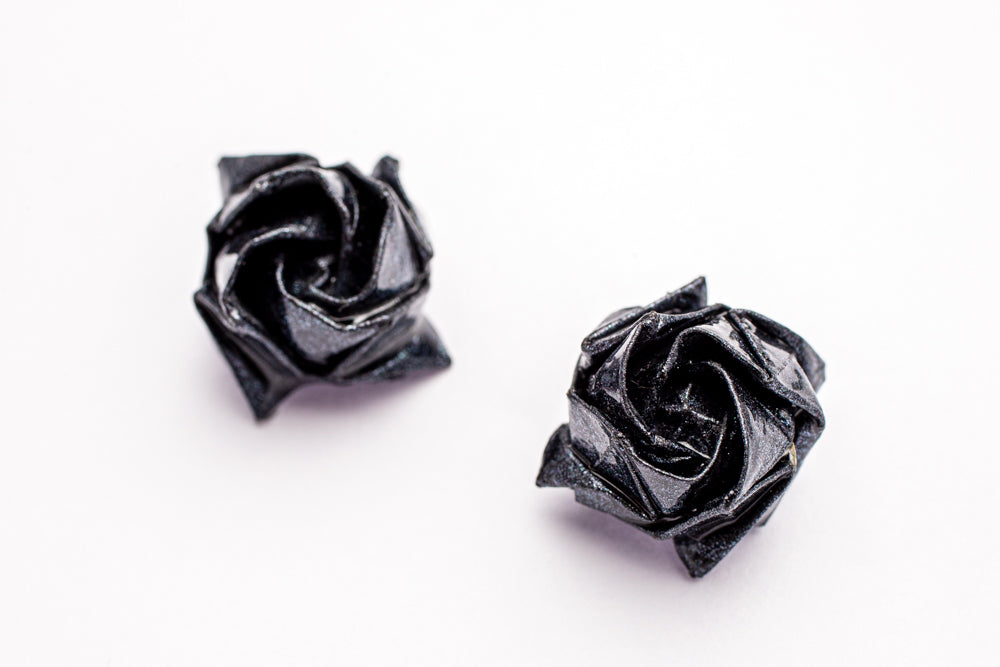 Topitos artesanales en forma de rosas en papel metálico azul sobre fondo blanco