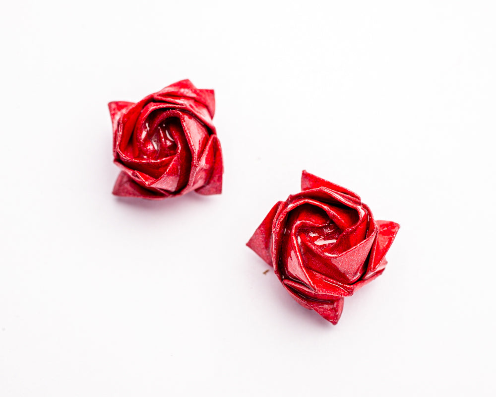 Topitos artesanales en forma de rosas en papel metálico rojo sobre fondo blanco