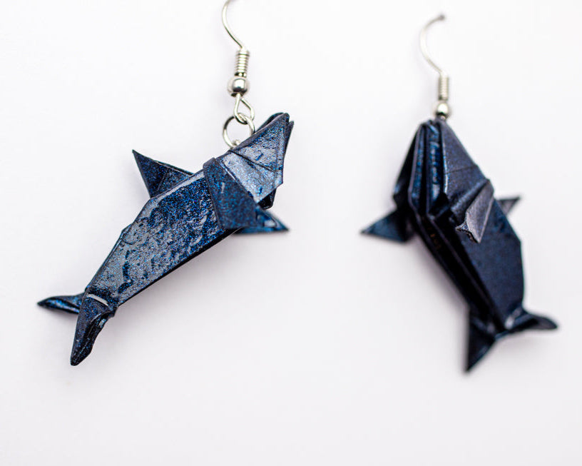 arete de origami en forma de tiburón hecho en papel azul con resina