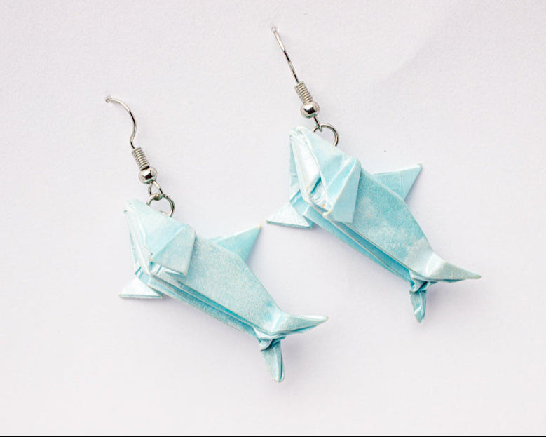 arete de origami en forma de tiburón hecho en papel azul claro con resina